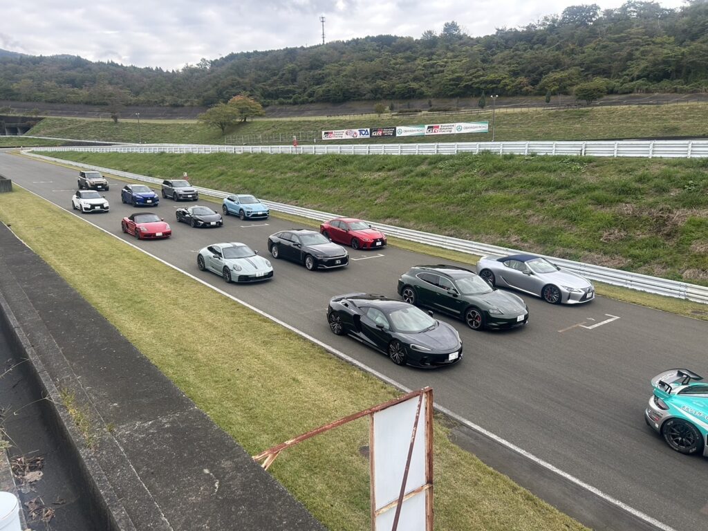 富士スピードウェイで行われたTOUCH Premium Test Driveの試乗車整列シーン。ポルシェ、マクラーレン、レクサス、ランドローバーなど高級車がサーキット上に並ぶ様子