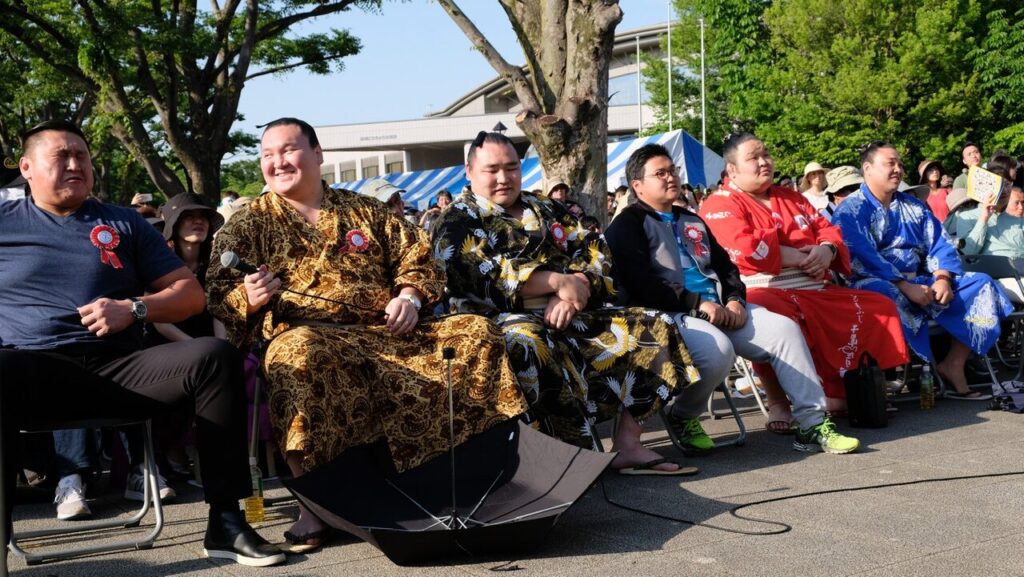 モンゴル相撲ブフ選手たちがイベント会場で並んで座る様子